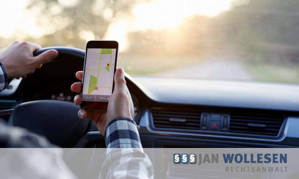 Mann hält während der Autofahrt ein Smartphone in der Hand