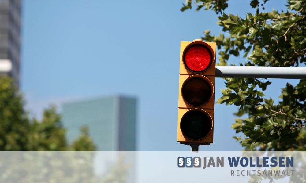 Rote Ampel bei einem Rotlichtverstoß mit Hinweis auf Bußgeld, Punkte und Fahrverbot